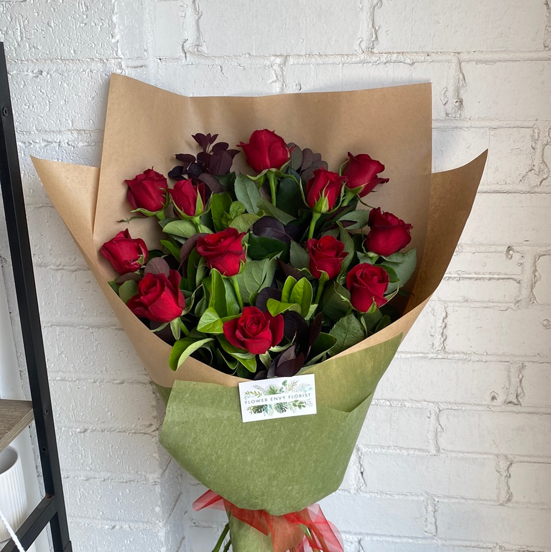 10 red roses long stem in a bouquet.